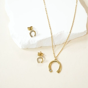 Golden U-shaped horseshoe jewelry set with necklace and stud earrings featuring clear zircons