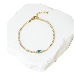 Elegante bracciale tennis placcato oro con zirconi bianchi e una pietra blu centrale quadrata
