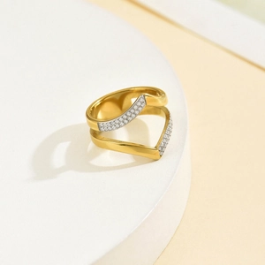 Detail view of double-layered V-shaped gold ring with pave-set zircon stones on white stand