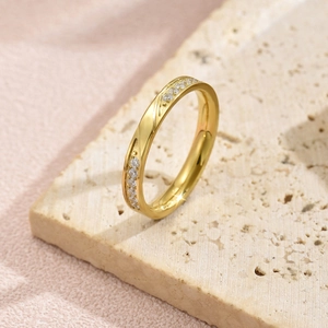 Detailaufnahme eines vergoldeten Edelstahlrings mit Zirkonstein-Inlay auf Stein