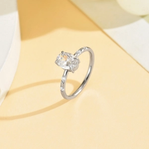 Dettaglio macro dell'anello in acciaio con zircone ovale e montatura a quattro griffe