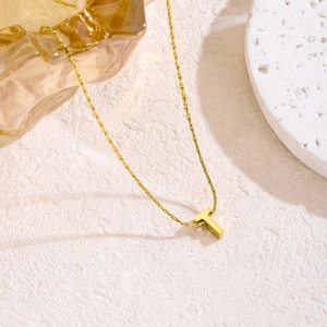 3D Gold-Halskette mit T-Buchstaben-Anhänger aus Edelstahl auf edlem Steingrund