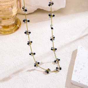Collar bohemio de flores con cuentas y cadena de titanio dorado sobre arena texturizada