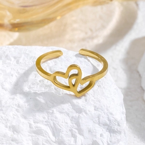 Anillo abierto de corazón dorado pulido presentado sobre una piedra natural con textura