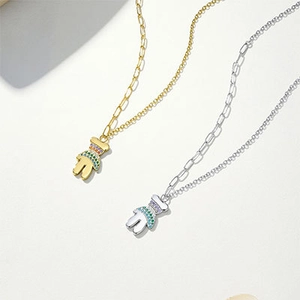 Detailopname van beerhanger met gekleurde zirkoonstenen en paperclip-schakelketting