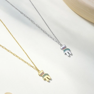 Detail van beer hanger kettingen in goud en zilver met kleurrijke zircon stenen