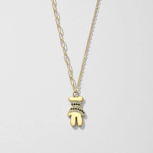 Detail van gouden teddybeer hanger met gestreepte zirkonia op een asymmetrische ketting