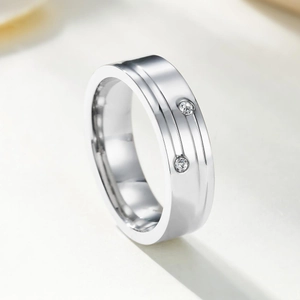 Macro shot of silver stainless steel ring with two parallel grooves and set round diamonds