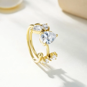 Detail of layered gold open ring featuring pear-cut and round-cut cubic zirconia settings