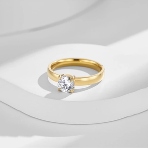 Primo piano dettagliato di un diamante rotondo incastonato in un anello d'oro a quattro griffe
