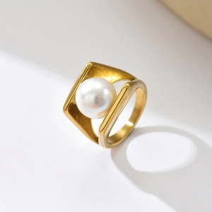 Makro-Detail des geometrischen Goldrings mit großer weißer Perle in quadratischer Fassung