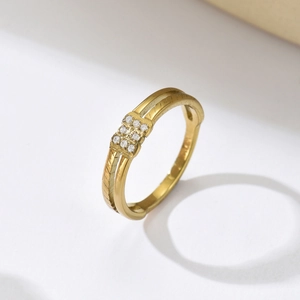 Nahaufnahme eines goldenen geometrischen Rings mit neun Diamanten und Doppelschiene-Textur