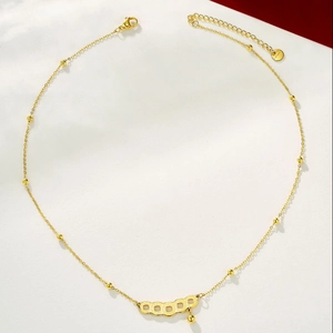 Detail van een 24K vergulde ketting met antieke muntpendants en verstelbare sluiting