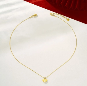 Detailopname van 24K vergulde hartvormige hanger ketting met traditioneel Fu-karakter