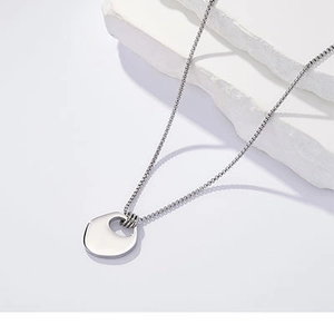 Detailaufnahme einer minimalistischen Edelstahl-Halskette mit geometrischem Anhänger