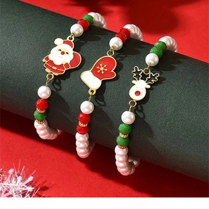 Detailed view of Christmas charm bracelets with Santa, reindeer and red glove pendants