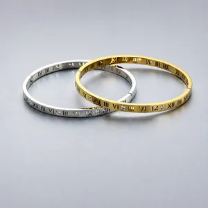 Dettaglio di bracciali in acciaio oro e argento con numeri romani e zirconi cubici