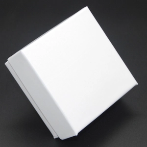 Boîte à bijoux carrée blanche minimaliste pour bagues et boucles sur fond noir mat