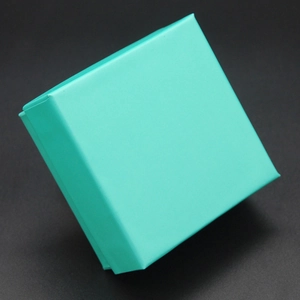 Boîte cadeau à bijoux carrée bleu Tiffany avec finition mate sur fond texturé