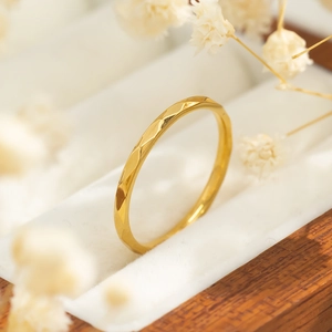 Minimalistische V-vormige gouden ring met ruitpatroon op een elegante witte juwelendoos