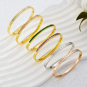 Set of six gold and silver stackable titanium bracelets with colorful baguette-cut zircons
