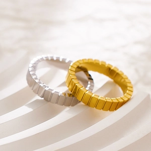 Makroaufnahme geometrischer Ice-Cube-Ringe in Gold und Silber mit quadratischen Facetten