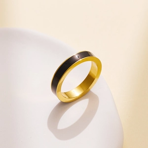 Detailaufnahme eines vergoldeten Edelstahlrings mit schwarzem Emaille-Inlay-Design