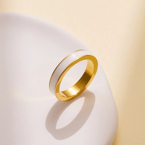 Detail eines minimalistischen Gold-Titanrings mit weißem Emaille-Inlay und Politur