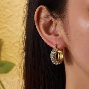 Close-up of 18k gold plated hoop earrings with pave set zircons on model's ear
