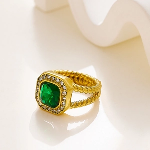 Detalle macro de anillo vintage dorado con piedra esmeralda cuadrada y banda torcida