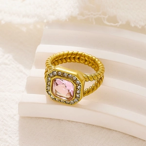 Detalle macro del anillo trenzado dorado con circón rosa cuadrado y halo de diamantes