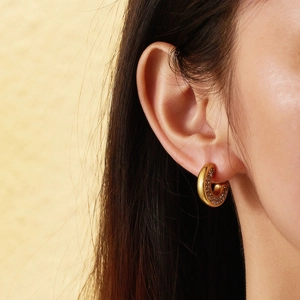 Close-up of minimalist 18k gold C-shaped earrings with inner micro-set zircon stones