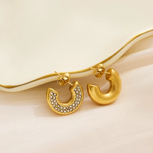Close-up of 18k gold plated C-shaped hoop earrings with pave-set shimmering crystals