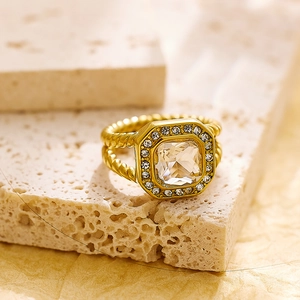 Vista macro detallada de un anillo vintage dorado con circón cuadrado y banda trenzada
