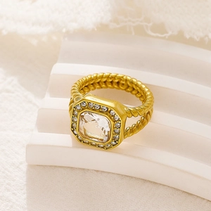 Primer plano de anillo dorado con circonita cuadrada y detalle de banda de cuerda