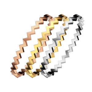 Brazaletes ondulados con letra W de acero de titanio en acabados oro, oro rosa y plata pulida