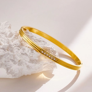 Detail view of a gold-plated stainless steel bangle with seven inlaid sparkling zircons