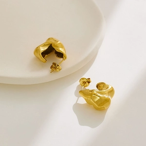 Gros plan détaillé de boucles d'oreilles dorées irrégulières style lave brillante