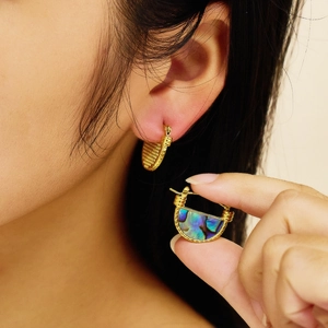 Detailed close-up of golden D-shaped hoop earrings with colorful abalone shell inlays