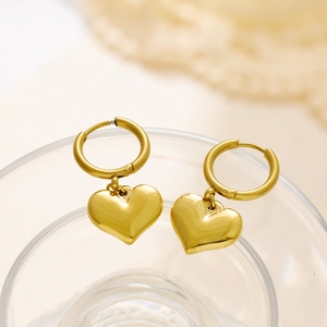 Macro detail of gold-plated stainless steel heart drop hoop earrings with polished finish