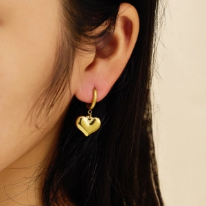 Close-up of 18k gold-plated stainless steel heart earrings worn by a model