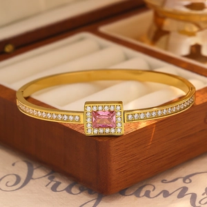 Macro shot of a gold-plated bracelet with rectangular pink zircon and white pave stones