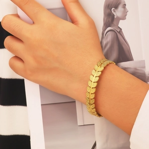 Détail du motif de feuilles de laurier dorées sur le bracelet ajustable en acier