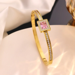 Detailed close-up of 18k gold-plated bangle with pink zircon and white pave crystals