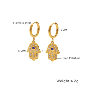 Detail showing 18k gold plated Hamsa hand stainless steel hoop earrings with blue stones