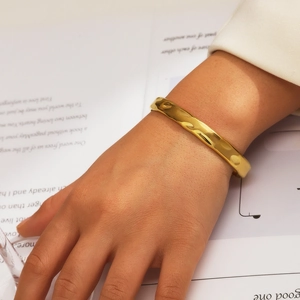 Vue détaillée du bracelet jonc doré en C avec texture martelée portée au poignet