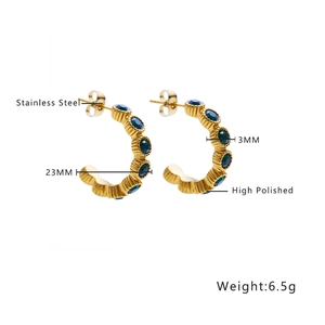 Detail view of 23mm stainless steel hoop earrings with green stones and high polished finish