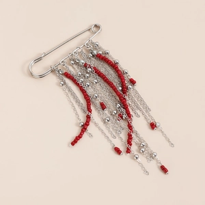 Broche épingle de sûreté vintage avec pompons argentés et perles rouges sur fond rose