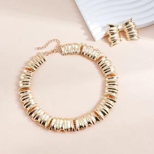 Vue détaillée de l'ensemble collier et boucles d'oreilles dorés avec texture plissée