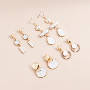 Dettaglio di quattro paia di orecchini vintage dorati con perle e inserti in conchiglia